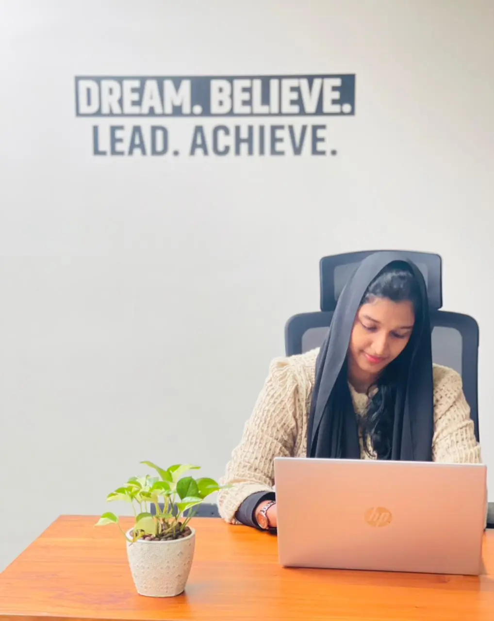 a best freelance social media marketer in doha qatar seated at a desk,working on her laptop